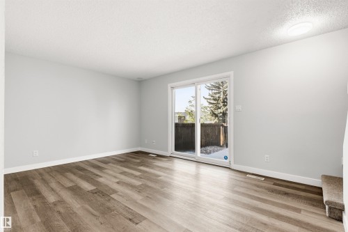 Spacious room featuring wood-finish flooring, light-toned walls, and white baseboards - 707 Clareview Road, Edmonton, AB - Indoor Photo Showing Other Room