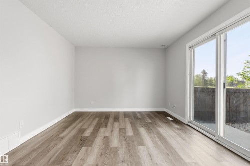 Spacious room with wood-finish flooring, light grey walls, and white trim - 707 Clareview Road, Edmonton, AB - Indoor Photo Showing Other Room