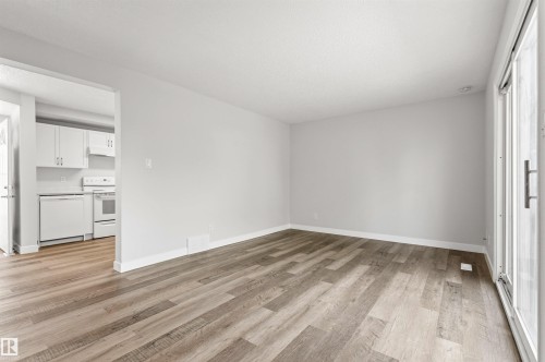 Spacious room featuring wood-finish flooring, light grey walls, and white baseboards - 707 Clareview Road, Edmonton, AB - Indoor Photo Showing Other Room