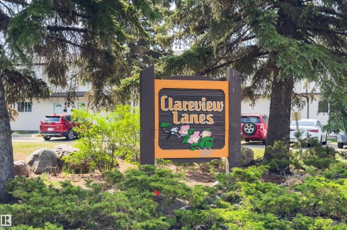 Prominent wooden community signage featuring a decorative floral motif - 707 Clareview Road, Edmonton, AB - Outdoor