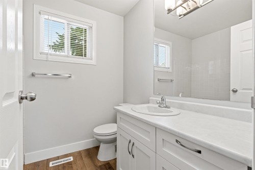 Bathroom featuring a vanity with an integrated sink, white cabinetry, and a large mirror - 707 Clareview Road, Edmonton, AB - Indoor Photo Showing Bathroom