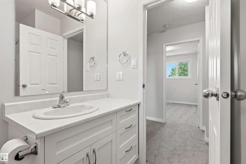 Bathroom vanity featuring a white countertop, oval undermount sink, and chrome faucet - 707 Clareview Road, Edmonton, AB - Indoor Photo Showing Bathroom