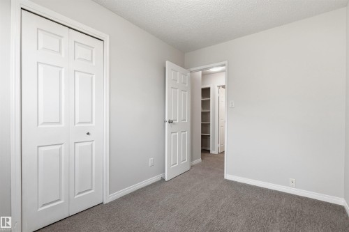 Neutral-toned room featuring a bifold closet door, a paneled interior door, and grey carpeting - 707 Clareview Road, Edmonton, AB - Indoor Photo Showing Other Room