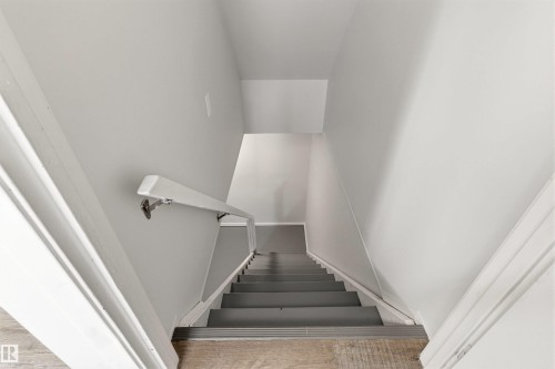 Staircase featuring light gray walls, white trim, a white handrail, and gray treads with silver-toned nosing - 707 Clareview Road, Edmonton, AB - Indoor Photo Showing Other Room