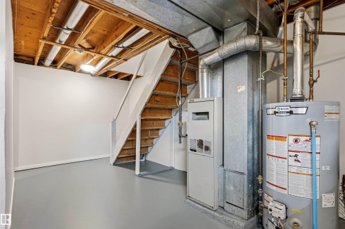 Utility area featuring a water heater, furnace, and exposed ceiling joists - 707 Clareview Road, Edmonton, AB - Indoor Photo Showing Basement