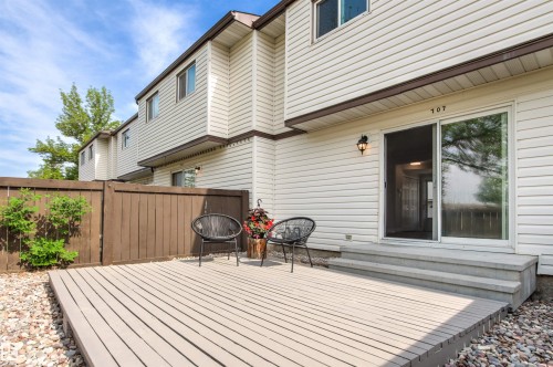 Ground-level deck with textured composite decking, framed by a wood privacy fence - 707 Clareview Road, Edmonton, AB - Outdoor With Deck Patio Veranda With Exterior