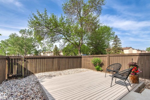 Private outdoor space with a composite deck, gravel border, and full privacy fencing - 707 Clareview Road, Edmonton, AB - Outdoor With Deck Patio Veranda