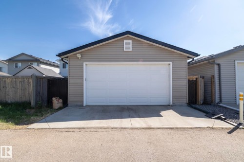 Detached two-car garage with a white overhead door and light gray horizontal siding - 4204 161 Avenue, Edmonton, AB - Outdoor With Exterior