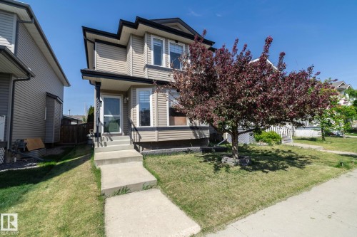 Two-story residence featuring light-colored siding, a dark trim roofline, and a covered front entry - 4204 161 Avenue, Edmonton, AB - Outdoor