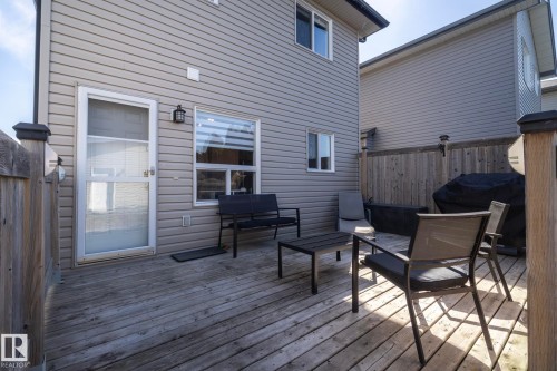 Rear exterior featuring a wood deck, horizontal vinyl siding, and white-framed windows - 4204 161 Avenue, Edmonton, AB - Outdoor With Deck Patio Veranda With Exterior