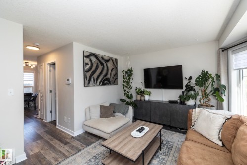 Spacious living area featuring wood-finish flooring, a bright window with blinds, and white baseboards - 4204 161 Avenue, Edmonton, AB - Indoor Photo Showing Living Room