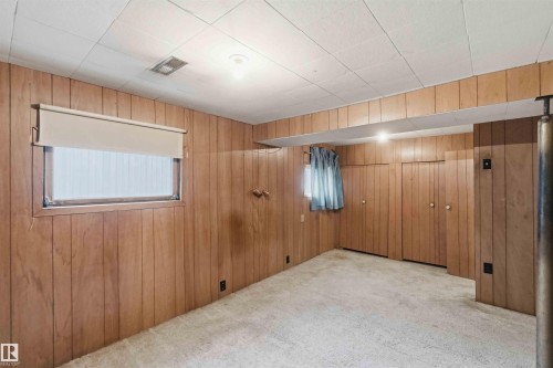 Room featuring wood paneling throughout, built-in storage closets, plush carpeting, and a drop ceiling with recessed lighting - 16 Michigan Street, Devon, AB - Indoor Photo Showing Other Room