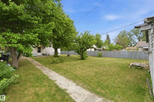 Expansive grassy yard with a gravel pathway and mature trees - 16 Michigan Street, Devon, AB - Outdoor