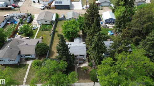 Aerial perspective showcasing a single-story residence with a gray shingle roof, surrounded by mature trees - 16 Michigan Street, Devon, AB - Outdoor With View