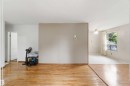 Light wood-finish flooring extending into a separate carpeted room - 16 Michigan Street, Devon, AB  - Indoor Photo Showing Other Room 