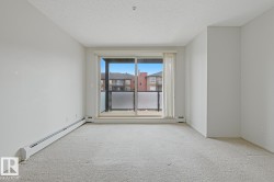 Light-colored wall-to-wall carpeting throughout this room, featuring a sliding glass door leading to a private outdoor balcony with a frosted panel railing - 