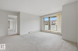 Spacious room featuring light-toned carpeting and neutral wall paint - 