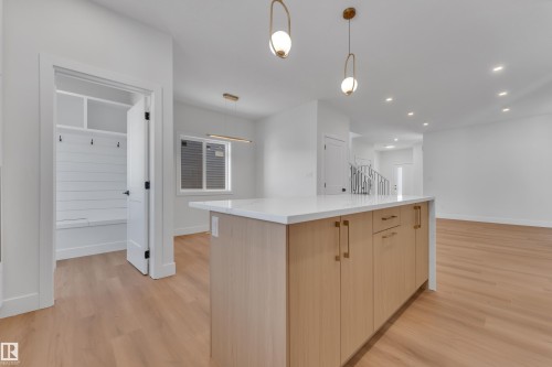 Kitchen island featuring light wood-finish cabinetry, gold-tone hardware, and a white countertop - 6092 179 Ave Nw, Edmonton, AB - Indoor