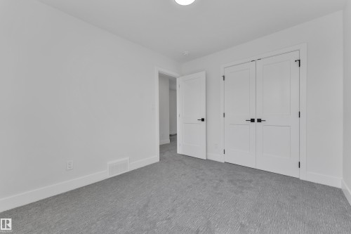 Bright room featuring white walls, white trim, and light grey patterned carpet - 6092 179 Ave Nw, Edmonton, AB - Indoor Photo Showing Other Room