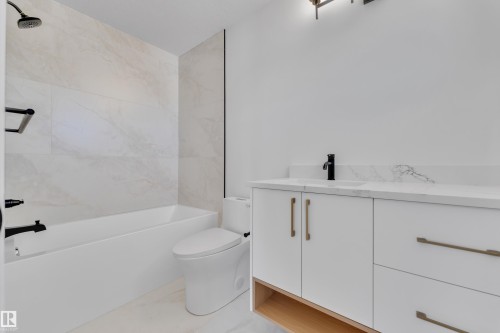Bathroom featuring a white vanity with gold-tone hardware, a white countertop, and a black faucet - 6092 179 Ave Nw, Edmonton, AB - Indoor Photo Showing Bathroom