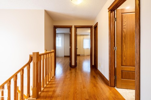 Upper-level hallway featuring wood-finish flooring and light-toned walls - 4632 151 Street, Edmonton, AB - Indoor Photo Showing Other Room