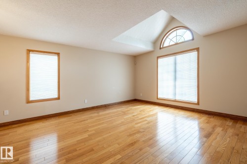 Spacious room featuring wood-finish flooring, neutral-toned walls, and a recessed ceiling element - 4632 151 Street, Edmonton, AB - Indoor Photo Showing Other Room