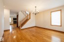 Hardwood flooring throughout, featuring a natural wood staircase with matching railing, baseboards, and window trim - 4632 151 Street, Edmonton, AB  - Indoor Photo Showing Other Room 