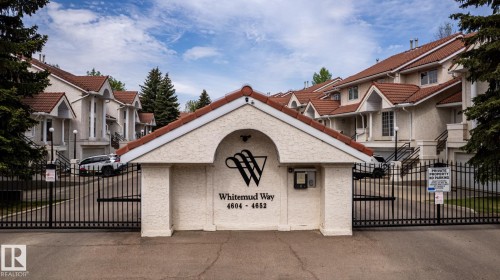 Wrought iron gates with an arched stucco entry feature, leading to multi-level residential units - 4632 151 Street, Edmonton, AB - Outdoor