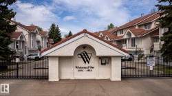 Wrought iron gates with an arched stucco entry feature, leading to multi-level residential units - 