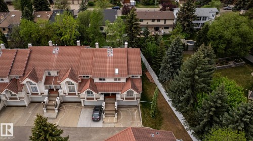 Terracotta tile roofing on a multi-unit property featuring white exterior siding - 4632 151 Street, Edmonton, AB - Outdoor With Deck Patio Veranda