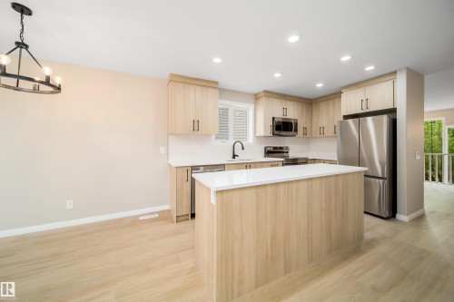 Contemporary kitchen featuring light wood-finish cabinetry, stainless steel appliances, a center island with a white countertop, and recessed lighting - 1212 Ormsby Lane, Edmonton, AB - Indoor Photo Showing Kitchen With Stainless Steel Kitchen With Upgraded Kitchen