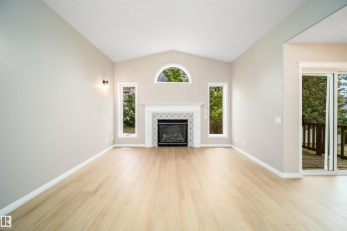 Living area with vaulted ceiling and light wood-finish flooring - 1212 Ormsby Lane, Edmonton, AB - Indoor Photo Showing Living Room With Fireplace
