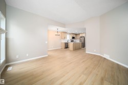 Open-concept living space with light wood-finish flooring - 