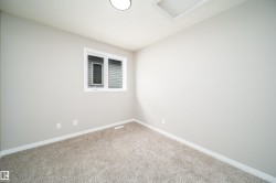 Carpeted room featuring a double-pane window, neutral wall paint, white trim, and a flush-mount ceiling light - 