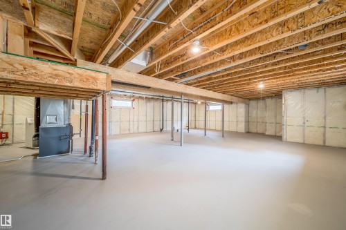 Unfinished lower level featuring an open layout, visible wood joists, structural support beams, and insulation on perimeter walls - 1212 Ormsby Lane, Edmonton, AB - Indoor Photo Showing Basement