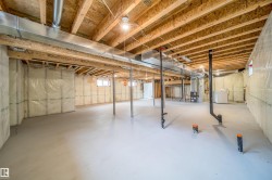 Unfinished basement with exposed ceiling joists and subflooring - 