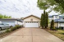 Attached garage with white panel door and upper window-style accents, featuring light-toned horizontal siding - 1212 Ormsby Lane, Edmonton, AB  - Outdoor 