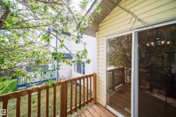 Private outdoor deck space featuring natural wood railing and flooring - 