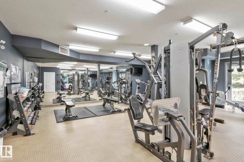 Dedicated fitness center featuring a full wall of mirrors and a variety of exercise equipment - 334 10121 80 Avenue, Edmonton, AB - Indoor Photo Showing Gym Room