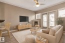 Living space featuring wood-finish flooring, a ceiling fan with integrated lighting, and crown molding - 334 10121 80 Avenue, Edmonton, AB  - Indoor Photo Showing Living Room With Fireplace 