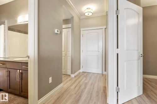 Entryway featuring wood-finish flooring, crown molding, and neutral wall tones - 334 10121 80 Avenue, Edmonton, AB - Indoor Photo Showing Other Room