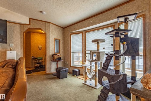 Living area featuring a bay window with horizontal blinds, textured wall panels with wood trim, and a recessed entryway - 1529 Range Road 272 Rural Parkland County, Alberta, Rural Parkland County, AB - Indoor Photo Showing Gym Room