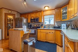Kitchen featuring wood-finish cabinetry, stainless steel appliances, and a built-in oven with stovetop - 