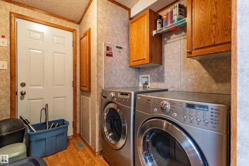 Dedicated laundry area featuring wood-finish flooring - 1529 Range Road 272 Rural Parkland County, Alberta, Rural Parkland County, AB - Indoor Photo Showing Laundry Room