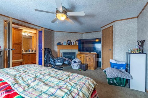 Bedroom featuring a ceiling fan, fireplace with a mantle, and carpet flooring - 1529 Range Road 272 Rural Parkland County, Alberta, Rural Parkland County, AB - Indoor Photo Showing Bedroom