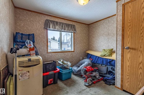 Room with textured wallpaper, carpet flooring, a single window, and a wood-finish door - 1529 Range Road 272 Rural Parkland County, Alberta, Rural Parkland County, AB - Indoor