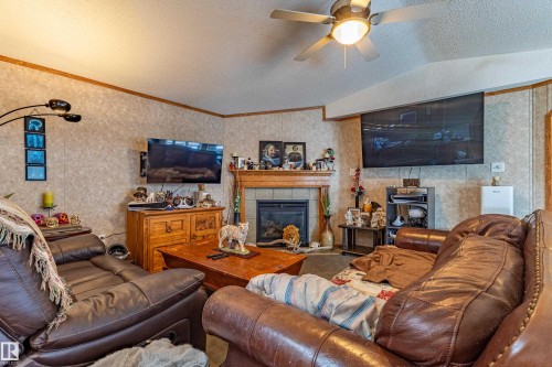 Living area featuring a fireplace with a wood mantel, tiled surround, and hearth - 1529 Range Road 272 Rural Parkland County, Alberta, Rural Parkland County, AB - Indoor Photo Showing Living Room With Fireplace