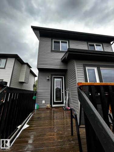 Rear exterior featuring gray horizontal siding and a dark wood-finish deck - 1868 30 Street Nw, Edmonton, AB - Outdoor With Exterior