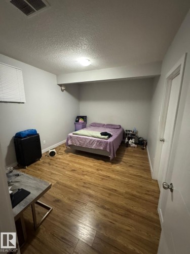 Bedroom with wood-finish flooring, recessed lighting, and a window with horizontal blinds - 1868 30 Street Nw, Edmonton, AB - Indoor