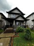Two-story residence featuring gray horizontal siding and vertical white siding accents - 1868 30 Street Nw, Edmonton, AB  - Outdoor With Deck Patio Veranda With Facade 